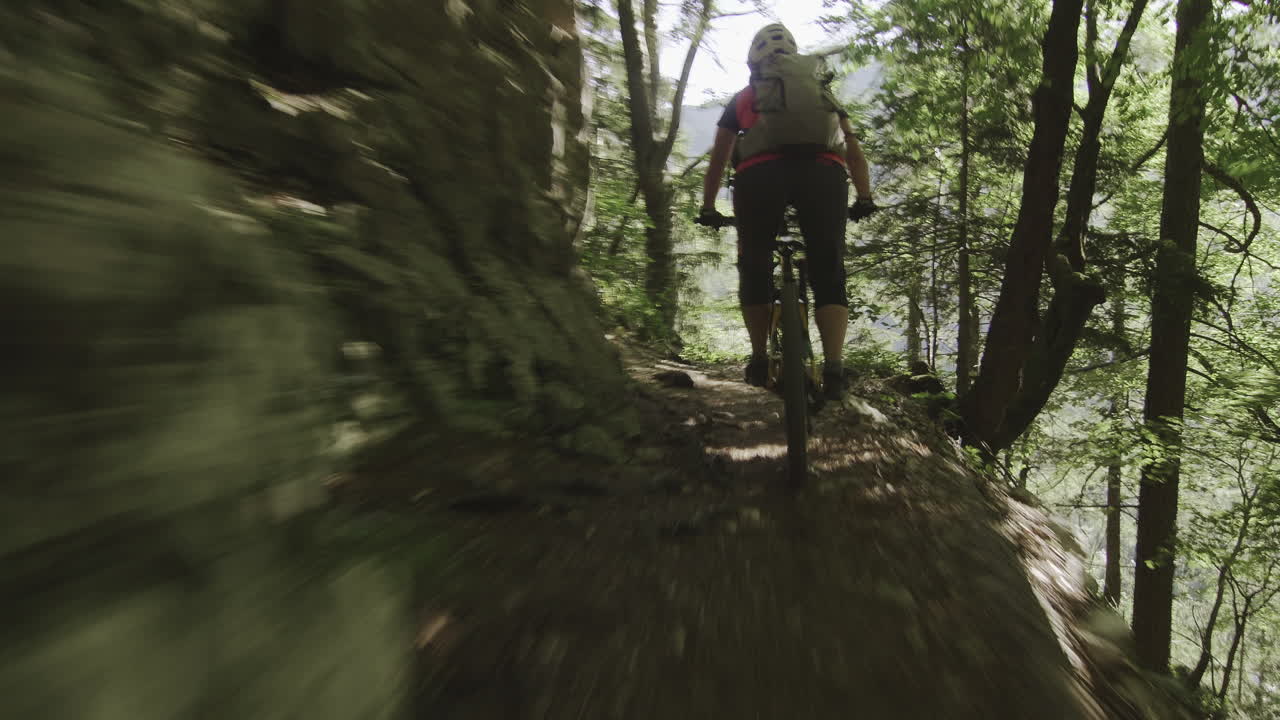 cerca de una joven montando su bicicleta de montaña en la pista forestal de adrenalina