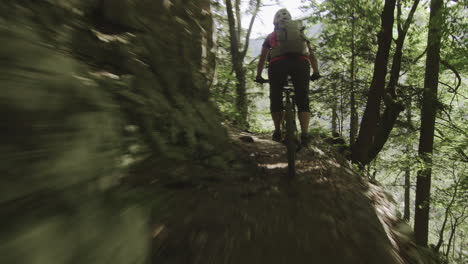 close up of young woman riding her mountain bike on the adrenaline forest track