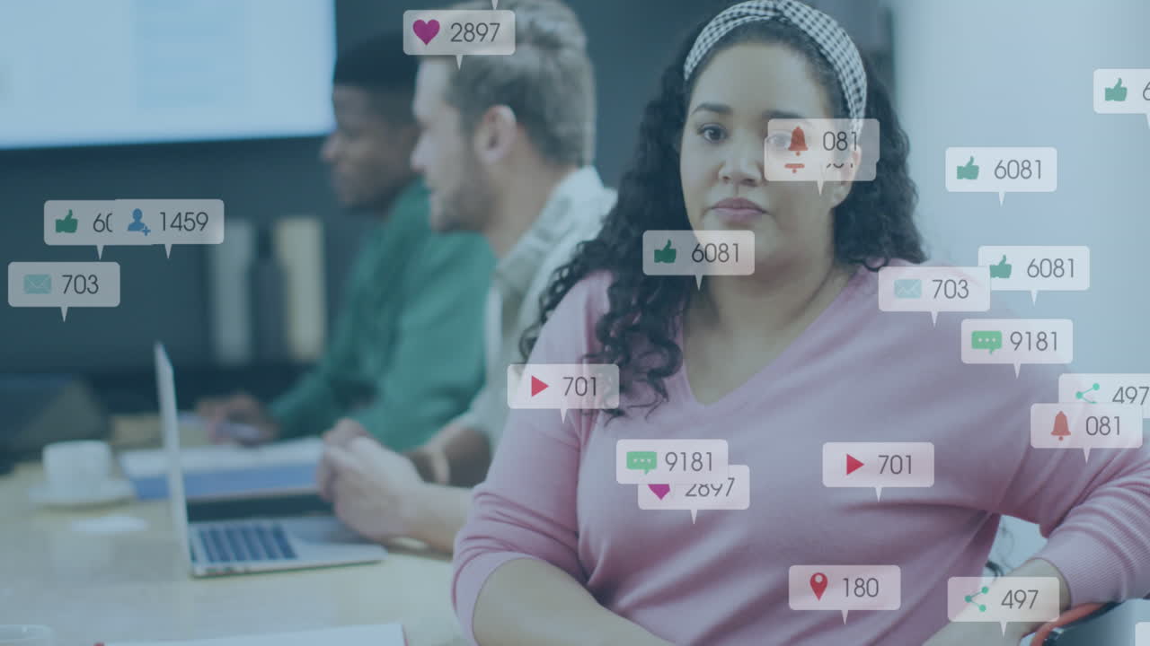 Animation of social media icons against biracial woman talking to her colleague at office