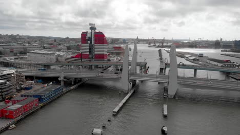 newly constructed structure in gothenburg, the modern gota river crossing, hisingsbron bridge against overcast sky background - aerial dolly out shot