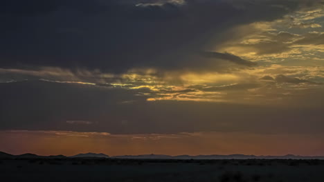 increíble toma de tiempo de la puesta de sol a través de las nubes sobre el majestuoso desierto del sahara durante la noche
