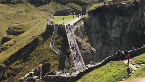 Toma-De-Timelapse-De-Turistas-Cruzando-El-Icónico-Puente-Del-Castillo-De-Tintagel-En-Tintagel