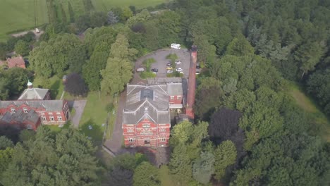 4k drone footage pushing in towards a brick building in the middle of a forest