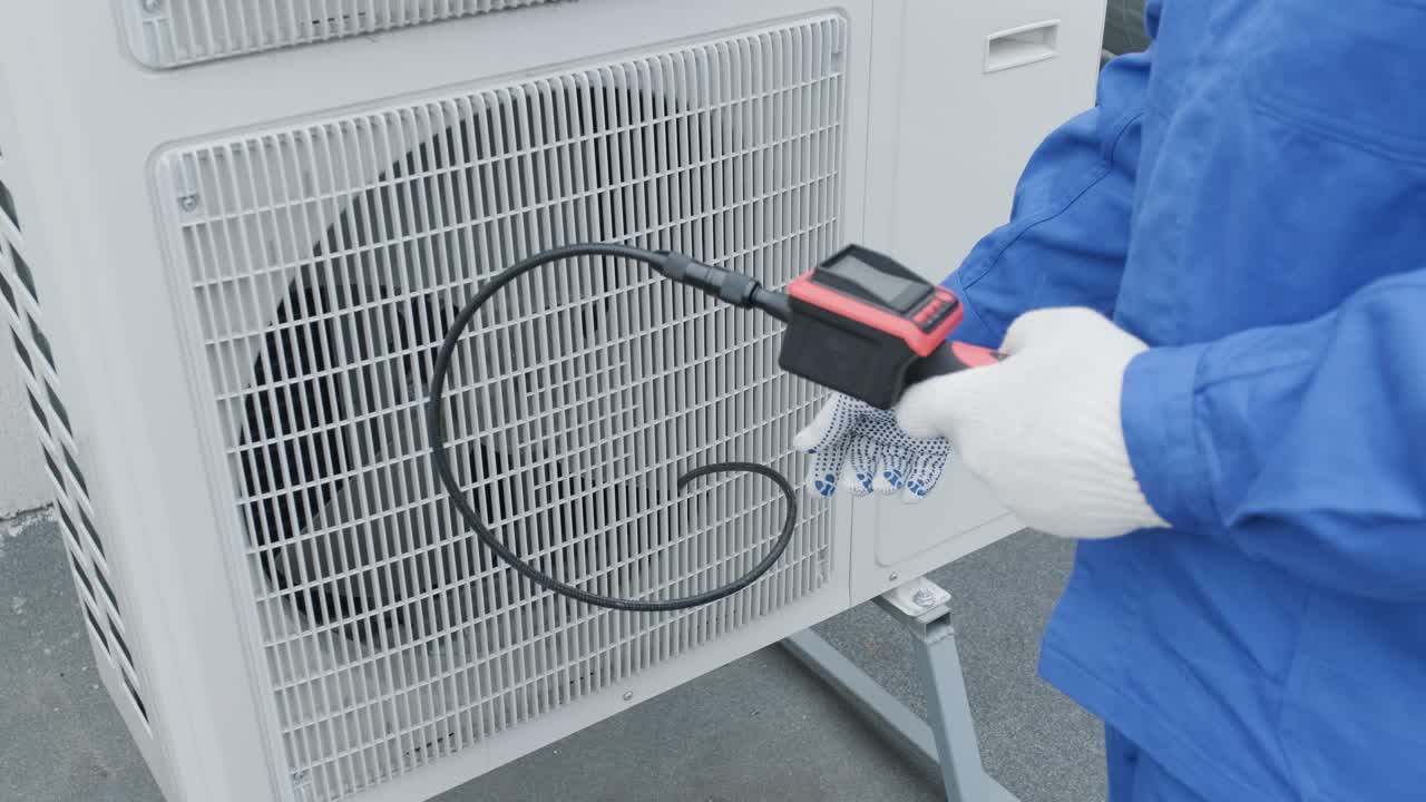 The technician uses a digital camera to check the clogging of the heat exchanger