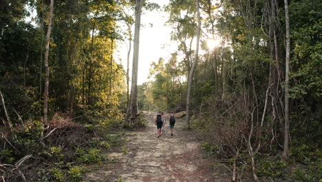 following behind a small group of people walking to the private tropical hideaway, lazy beach cambodia, aerial