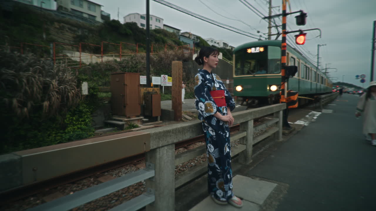Woman in Kimono next to a Train