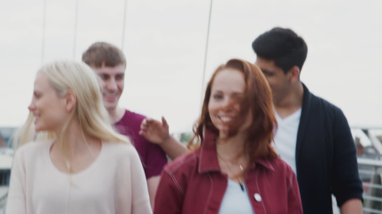 한 무리의 학생 친구 들 이 함께 도시 의 다리 를 가로질러 고 있다