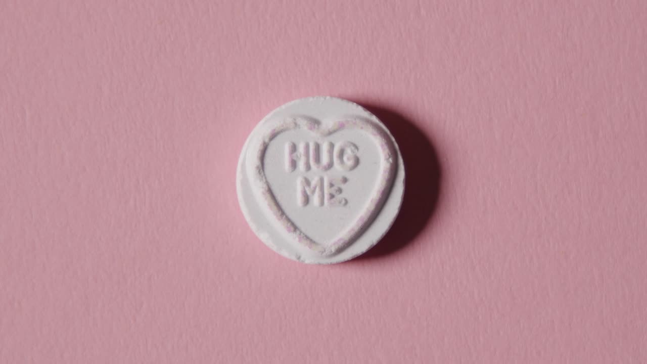 분홍색 배경에 포옹 메시지가 있는 하트 캔디