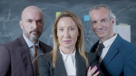 Portrait-shot-of-three-business-partners-standing-in-boardroom