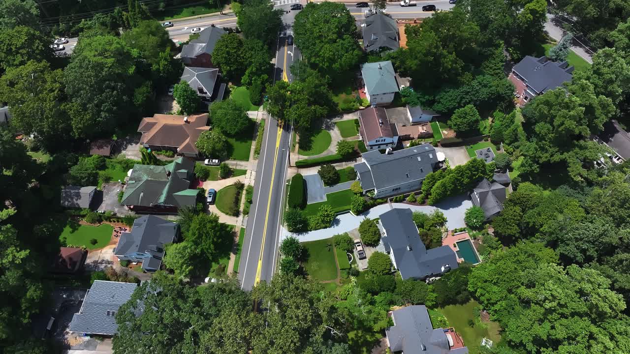Upper class neighborhood in suburb of Atlanta, Georgia. Sunny day with green Trees in luxury housing area. Villas and homes with swimming pool in yard. Aerial top down. Georgia, USA
