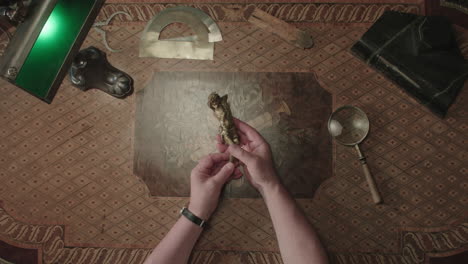 an older man evaluates an antique figure of jesus christ