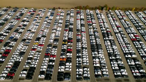 aerial footage of finished cars ready to be shipped on huge distribution center