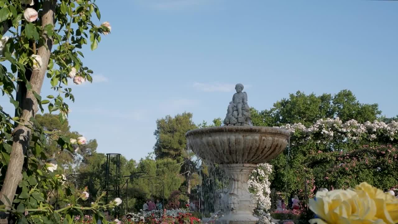 Fountain and statue in a beautiful rose garden in Retiro Park, Madrid. Scenic and picturesque garden view.