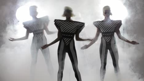 stylish dancers in futuristic outfits