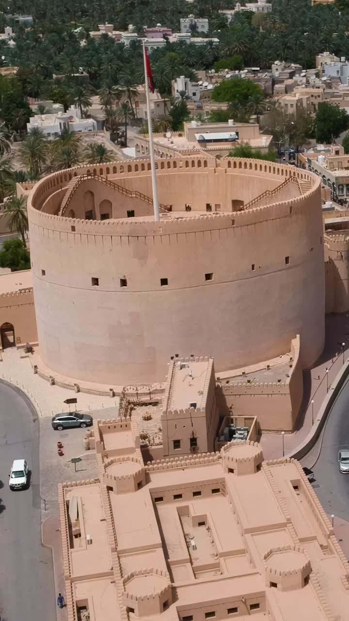 Vista aerea verticale con drone di Nizwa con forte e mura storiche nel Sultanato dell'Oman.