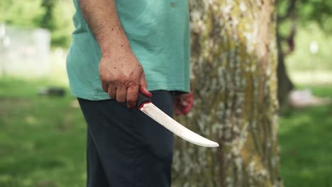 middle eastern man holding a knife he is using as he cuts sheep meat to eat in celebration of muslim, religious holiday ramadan, eid al-adha or eid al-fitr in cinematic slow motion