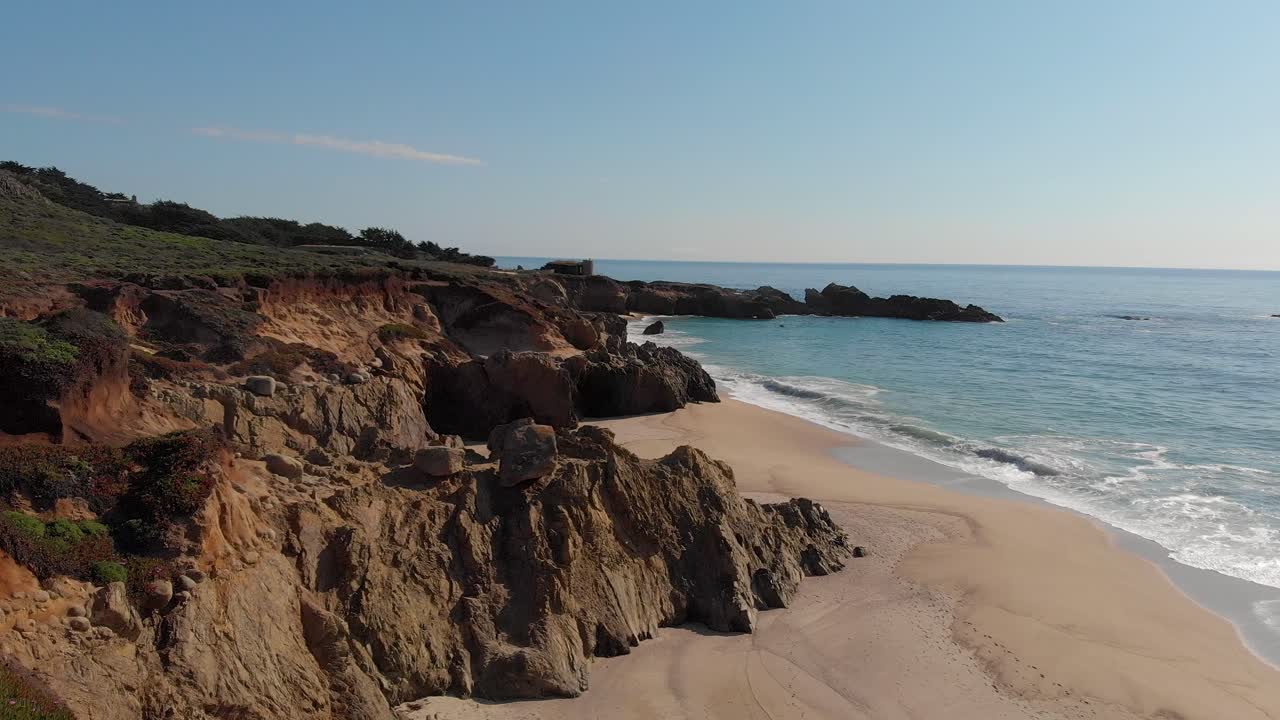 Ondas a embater numa praia rochosa ensolarada na Califórnia central