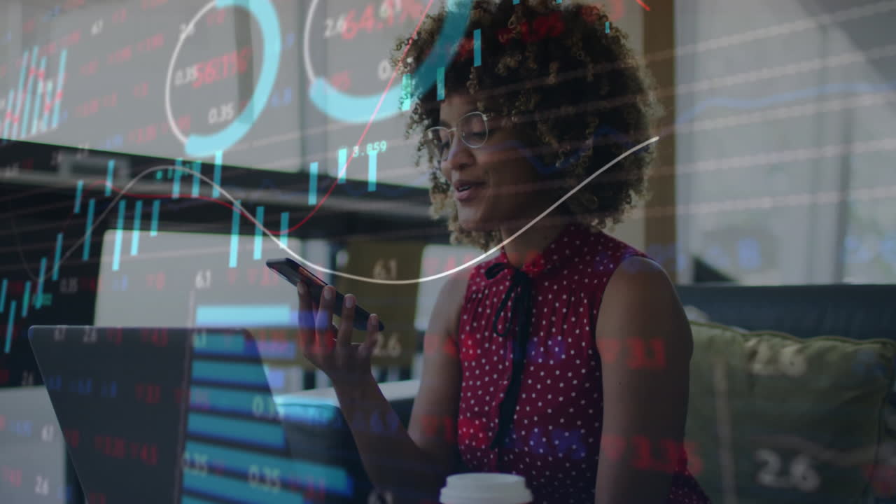 Using smartphone with financial charts animation, businesswoman working in office