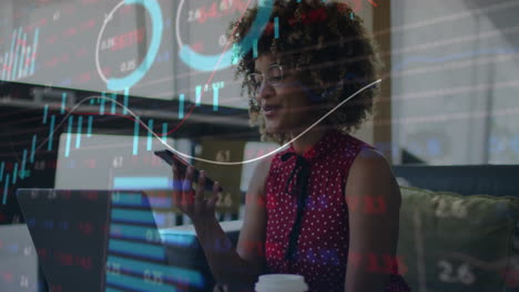 using smartphone with financial charts animation, businesswoman working in office
