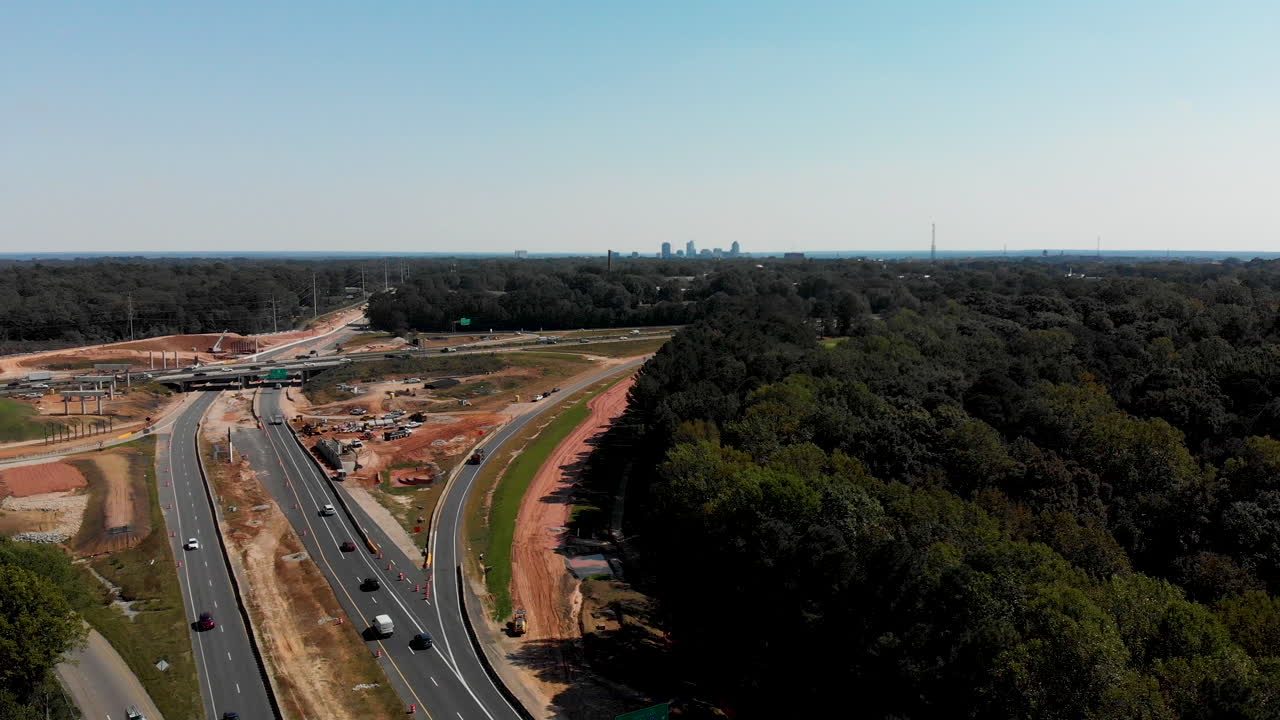 toma de drones de la construcción de una autopista con el centro de raleigh, carolina del norte, en la distancia.