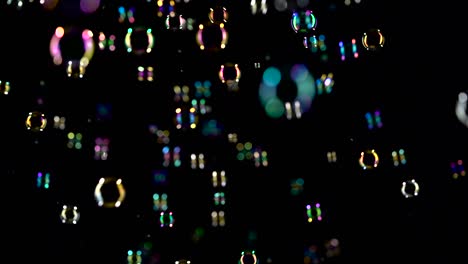 soap bubbles fly in the air and shimmer in different colors black background small transparent soap bubbles fly in the air and shimmer in bright different colors black background