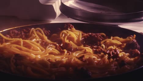 hot spaghetti bolognese with meat and tomato sauce in a pan on the stove