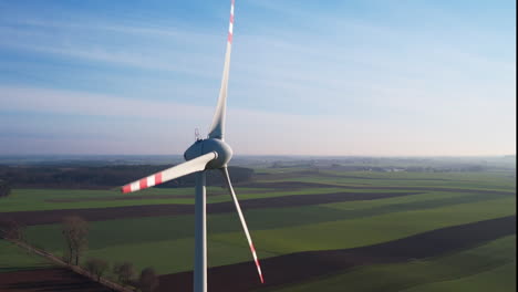 Aerogenerador-De-Primer-Plano-Aéreo-Girando-Al-Atardecer-En-El-Campo-De-Cultivos-Polonia