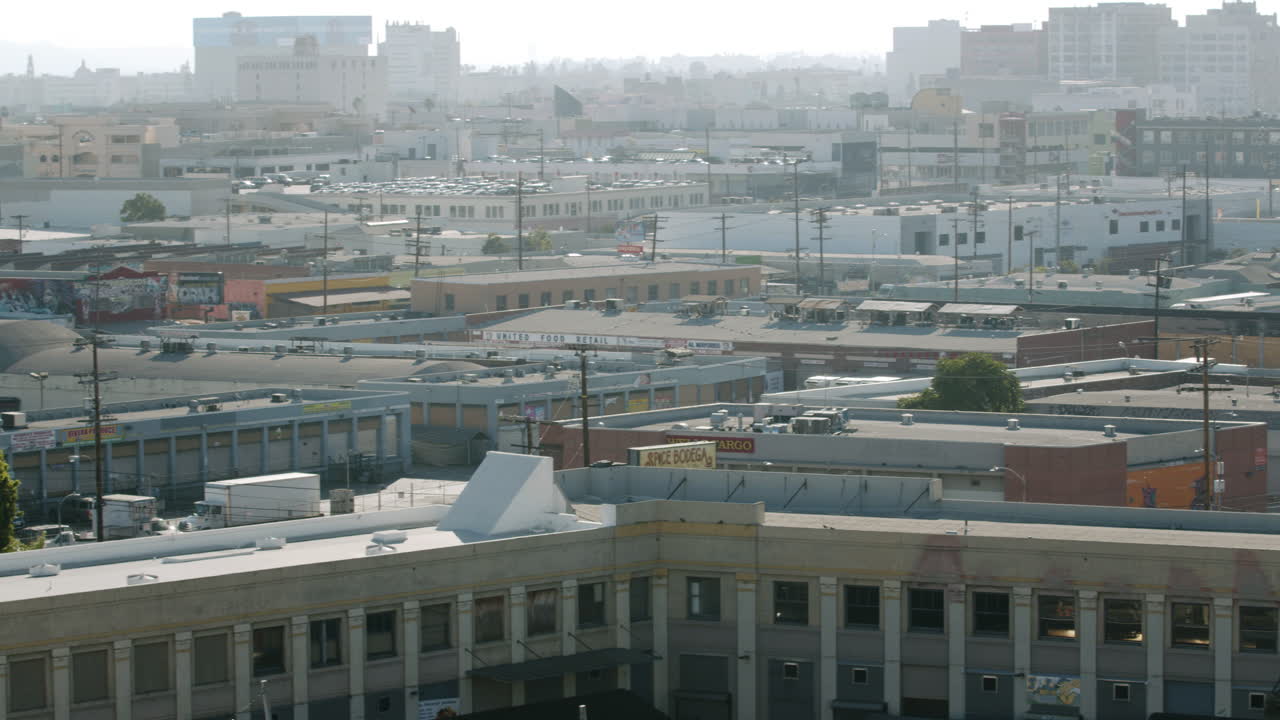 Aerial view of a sprawling urban landscape with numerous buildings under a hazy sky