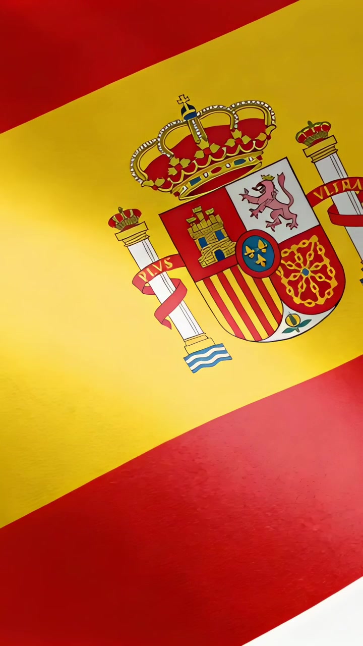 Pystyvideo: Lähikuva Espanjan lipusta liehumassa kevyessä tuulessa, paljastaen vaakunan.
