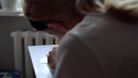 woman putting thread into needle to start sewing on a sewing machine