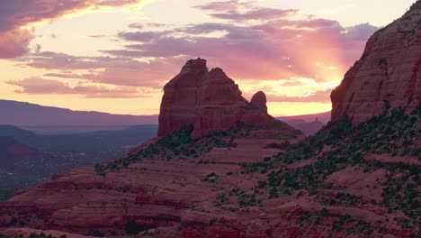 Aerial-parallax-around-Merry-Go-Round-Rock,-Sedona-Arizona,-picturesque-sunset-casts-light-into-sky