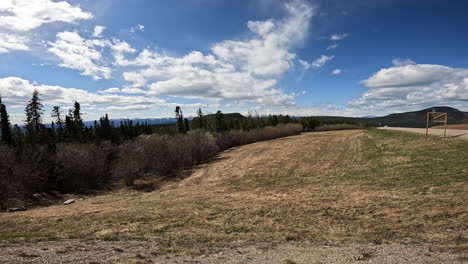 panoramic view of the muskwa river valley with boreal forest and rocky mountains in northern british columbia in early spring; concepts of adventure travel and road less traveld
