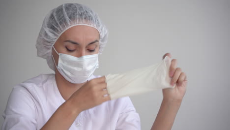 tired female doctor taking off medical gloves and face mask