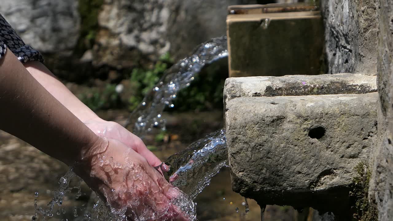 dos fuentes de agua viejas, mujer lavando las manos con agua de manantial natural