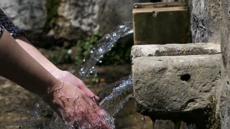 Zwei-Alte-Wasserquellen,-Frau-Wäscht-Hände-Mit-Natürlichem-Quellwasser