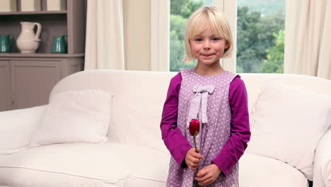 una niña linda sosteniendo una rosa roja