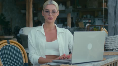mujer trabajando en una computadora portátil en un café