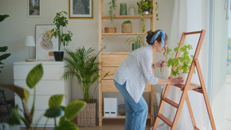 Frau-Tanzt-Und-Gießt-Blumen-Im-Wohnzimmer