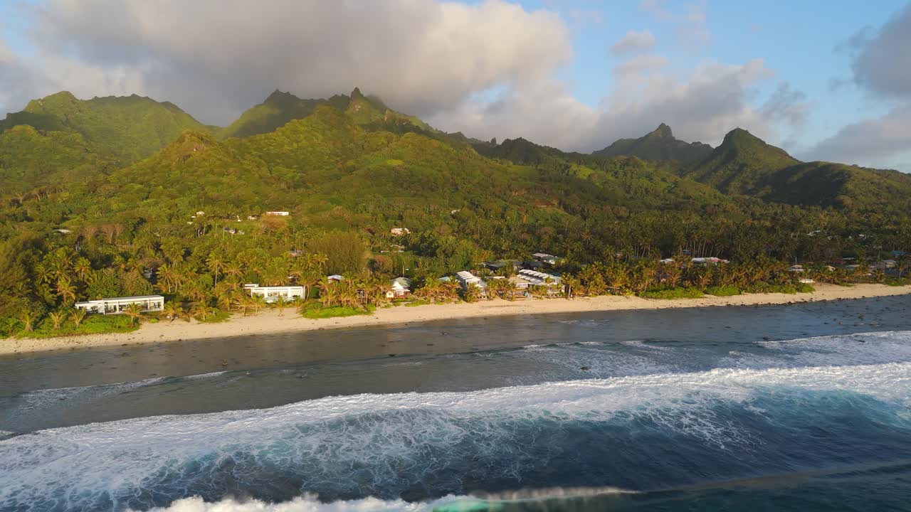 Breathtaking aerial view of Rarotonga’s lush mountains, coral reefs and pristine beaches at sunrise in Cook Islands.