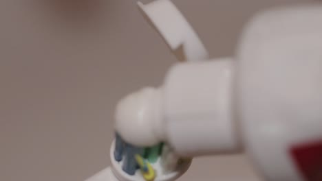 detail shot of toothpaste put on an electric toothbrush