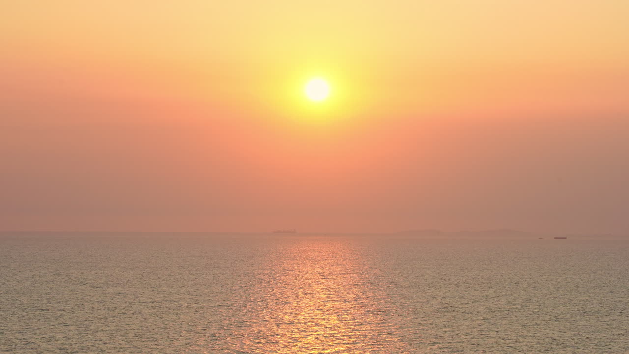 바다 위의 장엄한 일몰과 활기찬 분홍빛 하늘