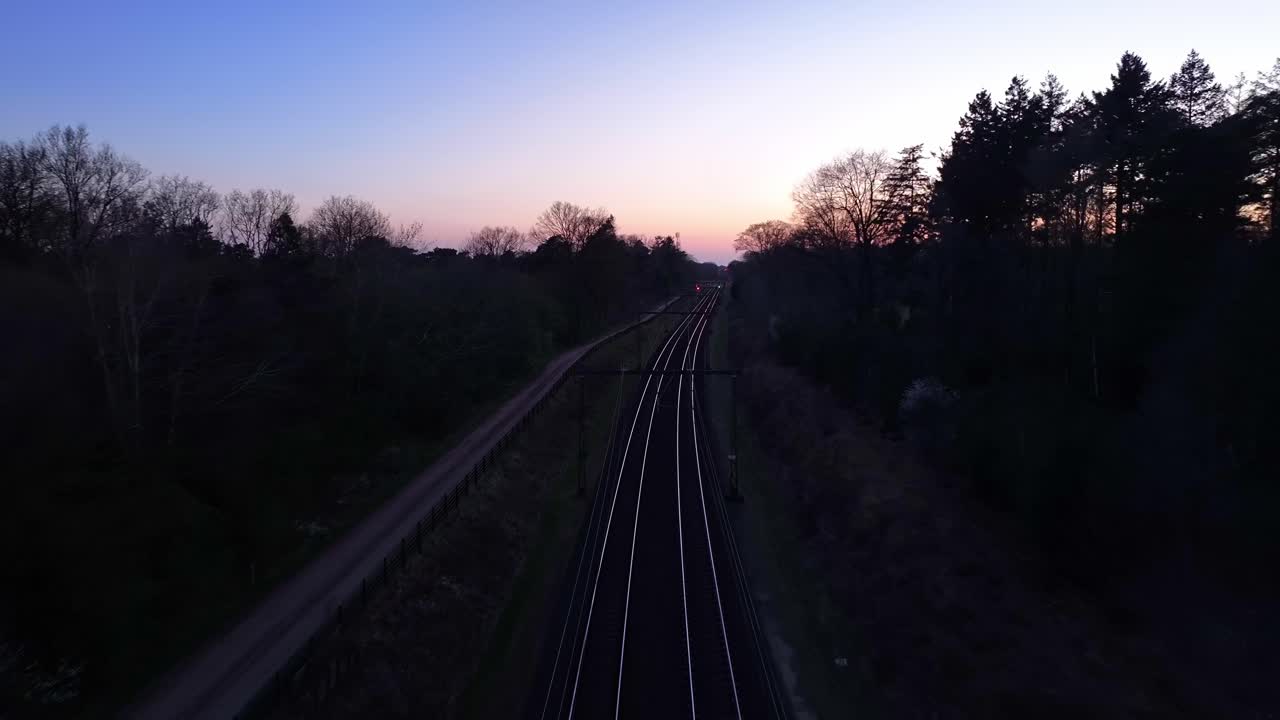 Railway Lines at Dusk: Long Shot of Train Moving Forward