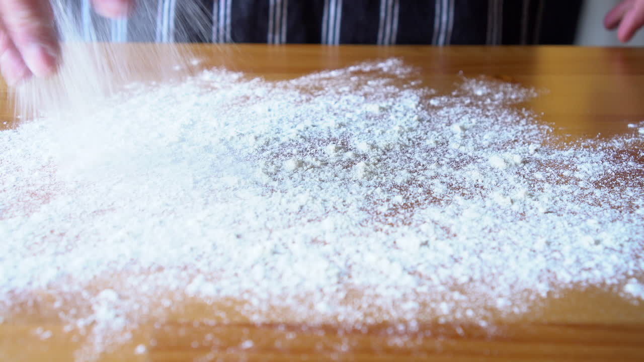 나무 표면에 밀가루를 선별하는 남자 요리사