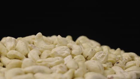 pile of raw cashew nuts on a dark background
