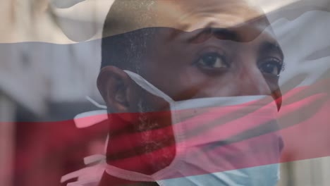 animación de la bandera de coumbia ondeando sobre un hombre afroamericano con máscara facial en la calle de la ciudad