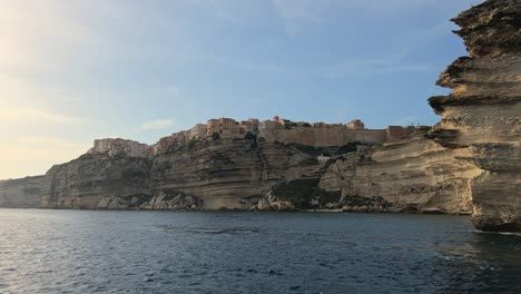 moving foward toward bonifacio corse city perched on high cliff seen from navigating sailboat in mediterran sea, corsica in france