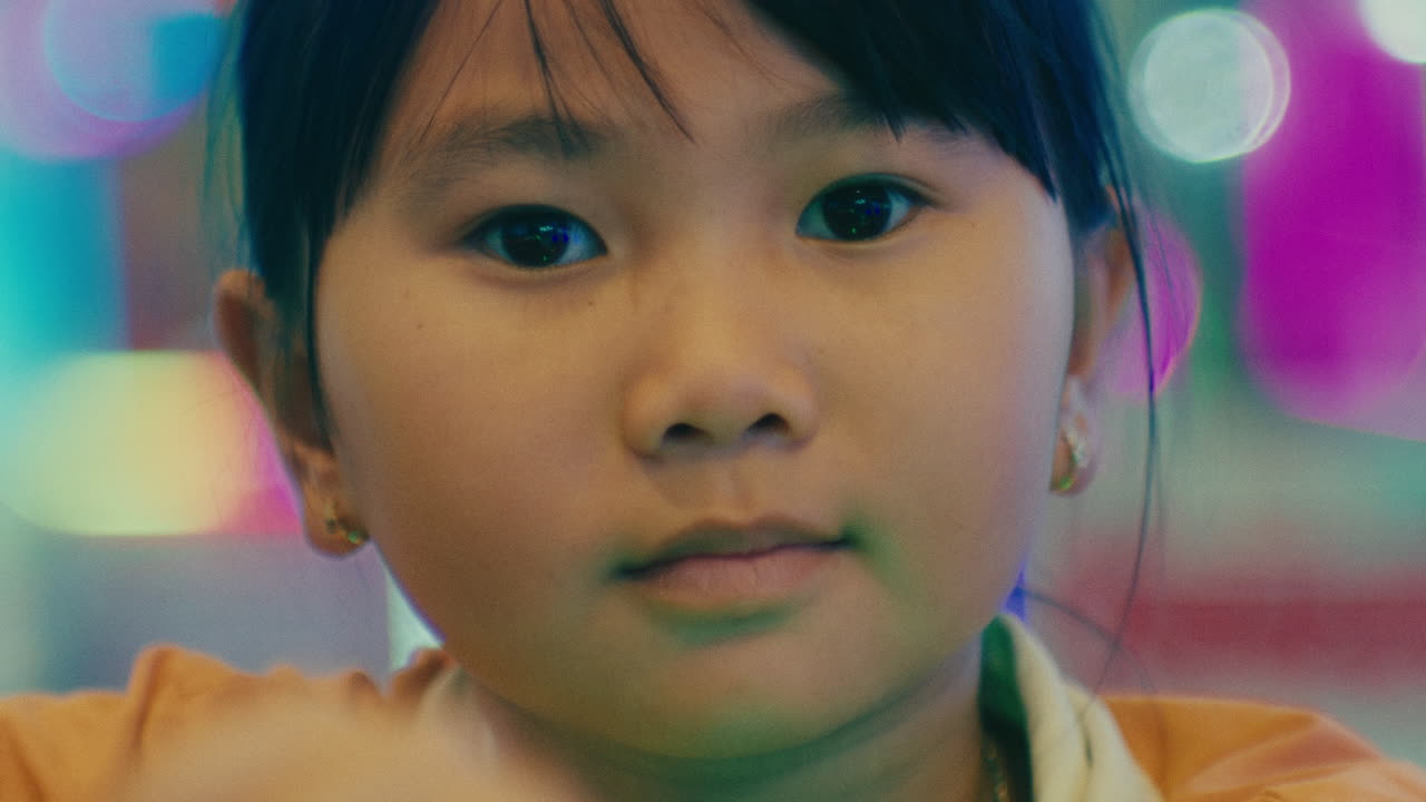 비디오 게임을 하는 귀여운 어린 아시아 소녀의 초상화, 그녀의 관심과 집중을 집중하고 성공하고 경기를 이기려고 노력합니다.