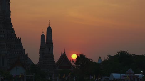 stunning close-up shot of a sunset behind wat arun temple in bangkok, thailand