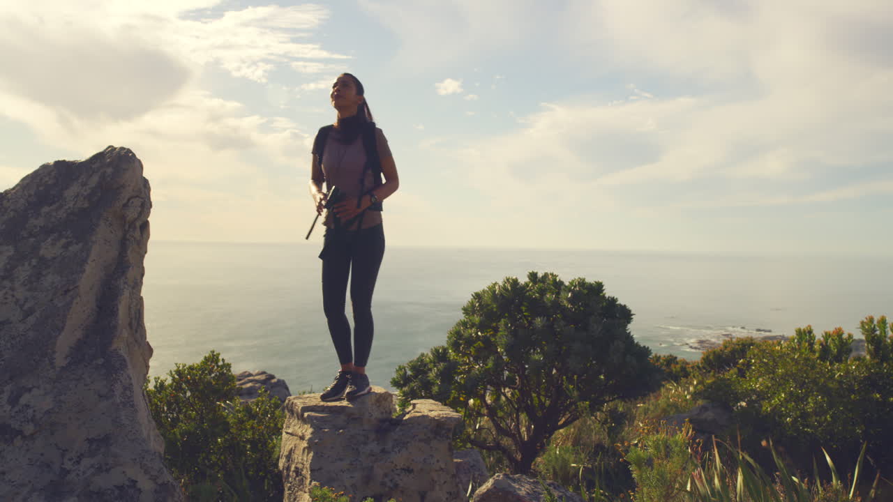 mujer activa en forma caminando por una montaña usando