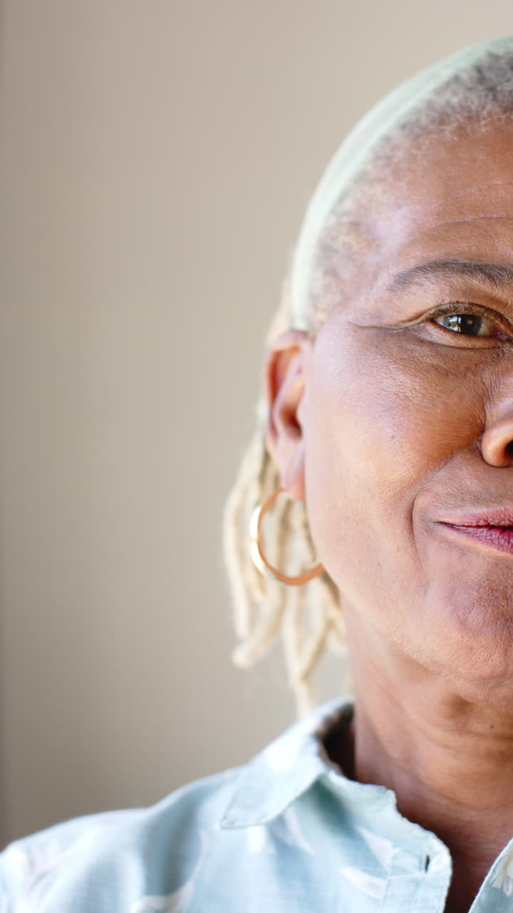 Vertical video: African American senior woman wearing hoop earrings, looking away